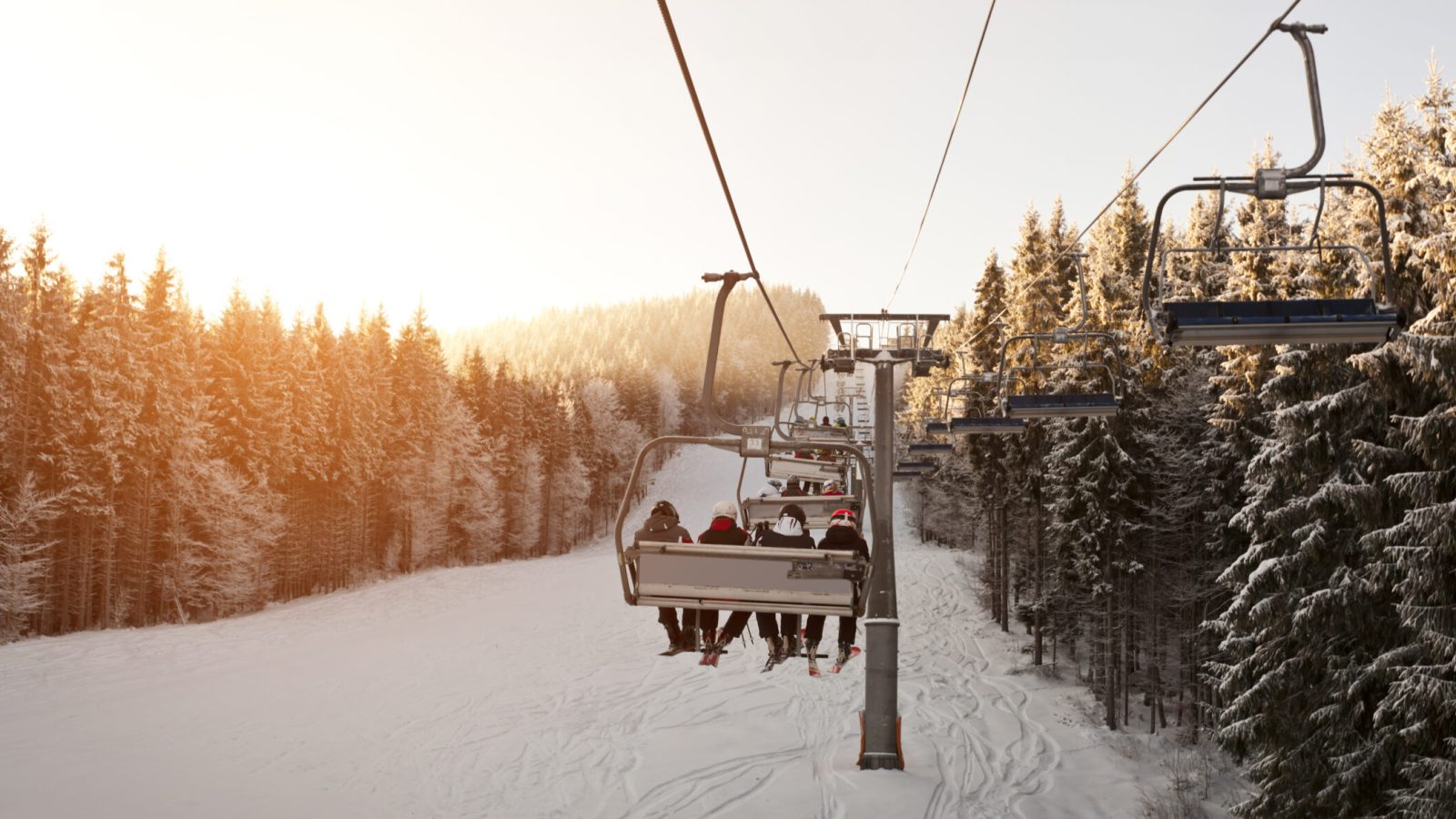 A scenic shot capturing a group of people on a ski lift, enjoying breathtaking views and winter excitement from above.