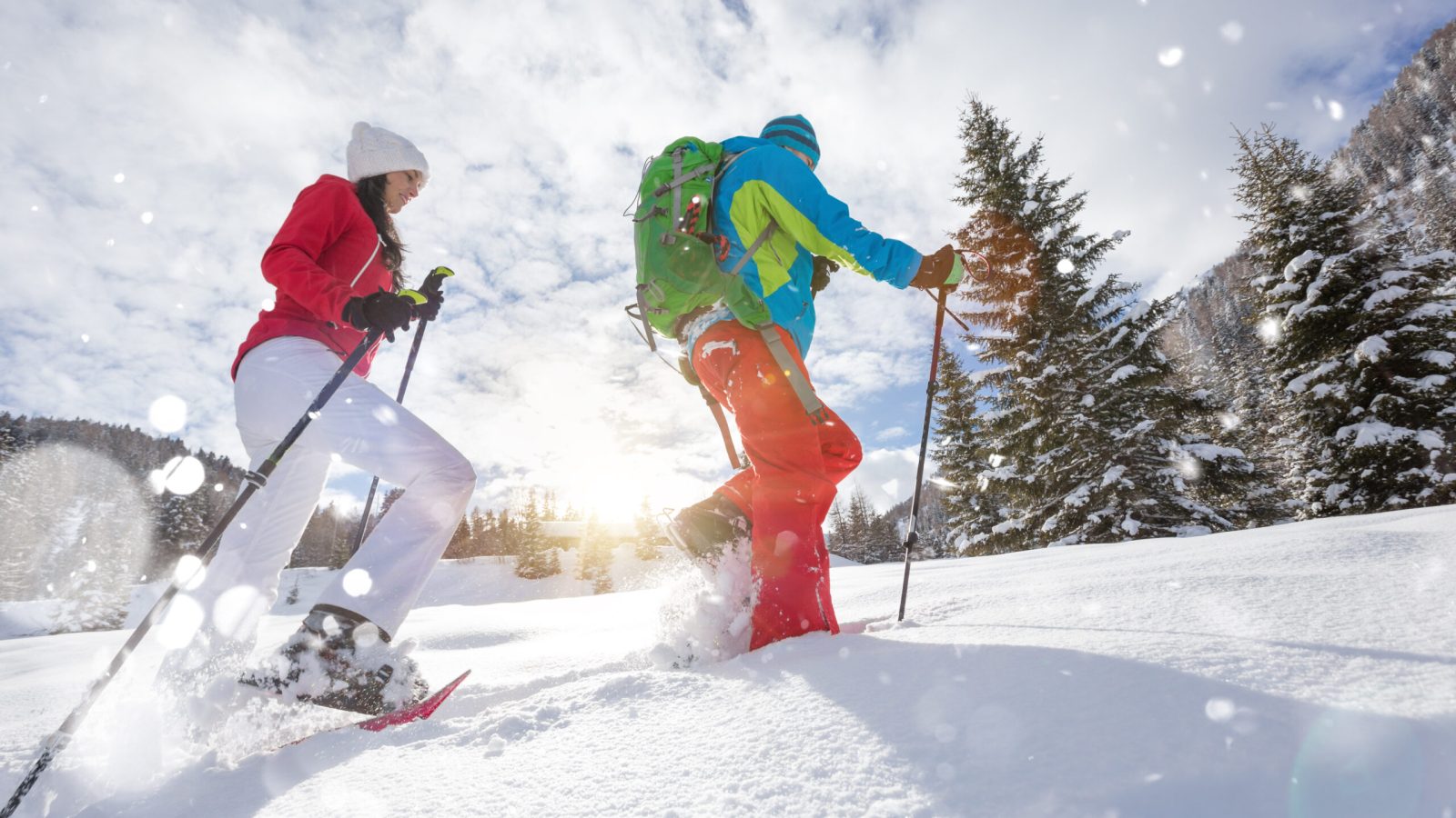 An image of a couple embarking on a snowshoeing adventure in the picturesque winter wonderland.